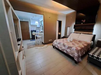 a large bedroom with a bed and a kitchen at NAIA Terminal 3 Condotel by Ann in Manila
