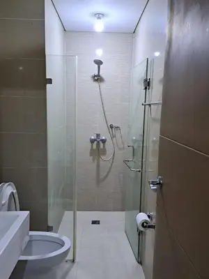 a bathroom with a shower and a toilet and a sink at NAIA Terminal 3 Condotel by Ann in Manila