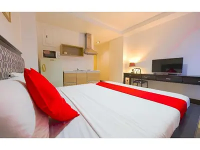 a bedroom with a large bed with red pillows at OYO 769 Poblacion Suites Polaris in Manila