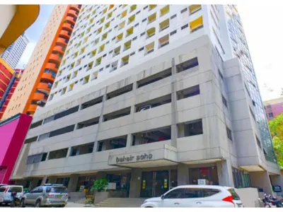 a hotel building with cars parked in front of it at OYO 769 Poblacion Suites Polaris in Manila