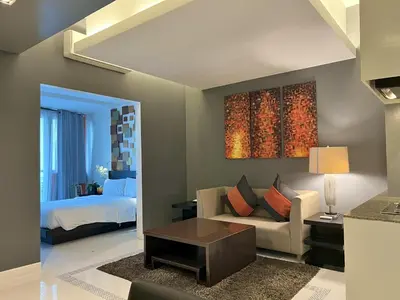a living room with a couch and a bed at KL Serviced Residences Managed by HII in Manila