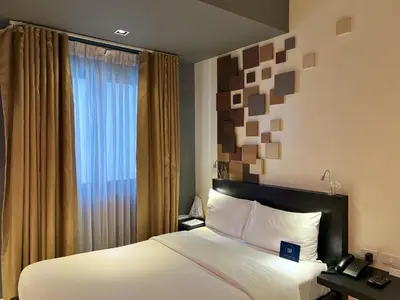 a hotel room with a bed and a window at KL Serviced Residences Managed by HII in Manila
