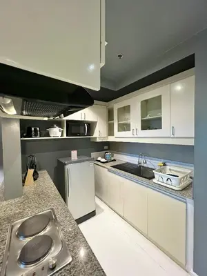 a kitchen with white cabinets and a sink at KL Serviced Residences Managed by HII in Manila