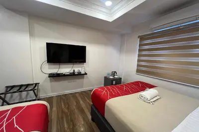 a room with two beds and a flat screen tv at Khotel near T3 Airport in Manila