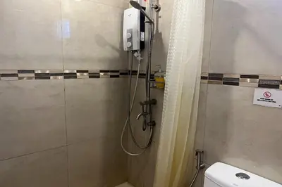 a shower in a bathroom with a toilet and a shower at Khotel near T3 Airport in Manila