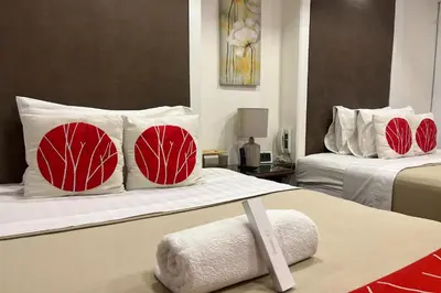 a hotel room with two beds with red and white pillows at Khotel near T3 Airport in Manila
