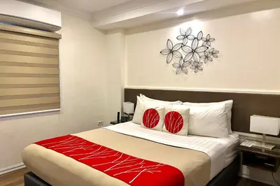 a bedroom with a large bed with red accents at Khotel near T3 Airport in Manila