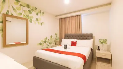 a hotel room with a bed with a mirror at RedDoorz Plus at La Belle Residences Makati City in Manila