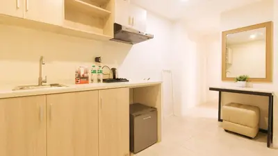 a kitchen with wooden cabinets and a sink and a mirror at RedDoorz Plus at La Belle Residences Makati City in Manila