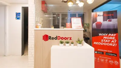 a red door store with potted plants on a counter at RedDoorz Plus at La Belle Residences Makati City in Manila