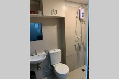 a bathroom with a toilet and a sink at Anuva Condominium with Netflix in Manila