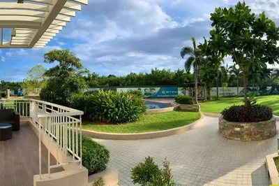 a resort with a pool and palm trees at Anuva Condominium with Netflix in Manila