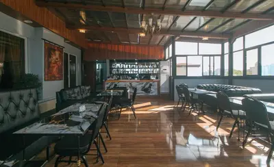 a restaurant with tables and chairs and a bar at RedDoorz Plus at Canley Residential in Manila