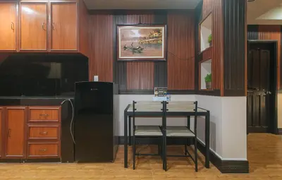 a kitchen with a table and a black refrigerator at RedDoorz Plus at Canley Residential in Manila