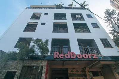 a white building with a red book sign on it at RedDoorz Plus at Canley Residential in Manila