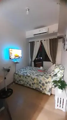 a bedroom with a bed and a flat screen tv at Spring Residence in Manila