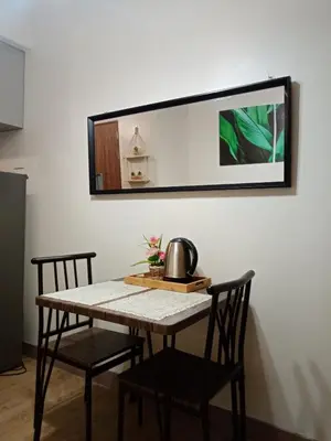 a table with two chairs and a mirror on a wall at Spring Residence in Manila