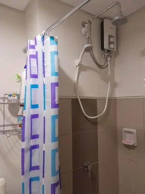 a shower in a bathroom with a shower curtain at Spring Residence in Manila