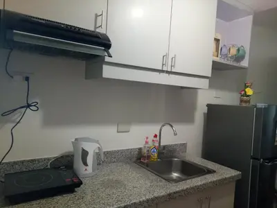 a small kitchen with a sink and a refrigerator at Spring Residence in Manila