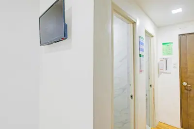 a flat screen tv hanging on a wall next to a door at Collection O Metro Manila near University Belt formerly 1318 Residences in Manila