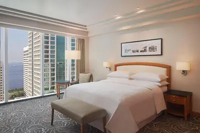 a hotel room with a bed and a large window at Sheraton Manila Bay in Manila