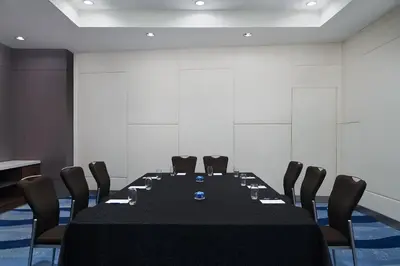 a conference room with a black table and chairs at Sheraton Manila Bay in Manila
