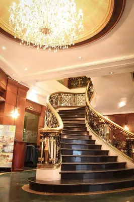 a spiral staircase in a building with a chandelier at CityState Tower Hotel in Manila