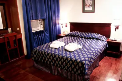 a hotel room with a bed with towels on it at CityState Tower Hotel in Manila