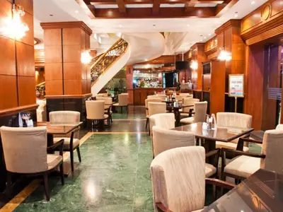 a restaurant with wooden floors and tables and chairs at CityState Tower Hotel in Manila