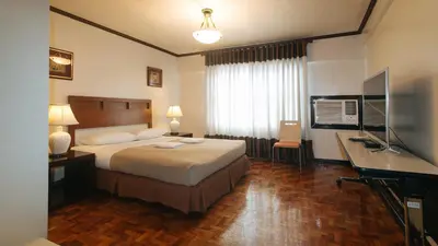 a hotel room with a bed and a television at El Rico Suite Makati by RedDoorz in Manila