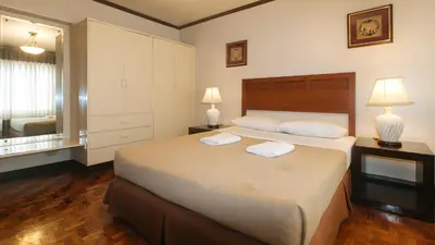 a bedroom with a large bed with two towels on it at El Rico Suite Makati by RedDoorz in Manila