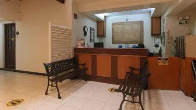 two chairs sitting in a room with a counter at El Rico Suite Makati by RedDoorz in Manila
