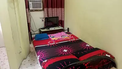 a small bed in a room with a tv at Belen Favila Transient rooms near Airport Terminal 3 in Manila
