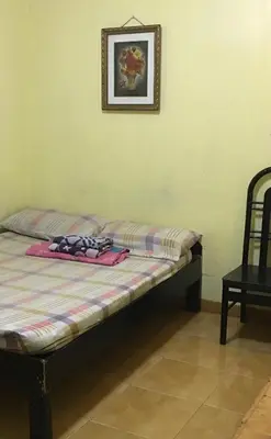 a bed in a room with a picture on the wall at Belen Favila Transient rooms near Airport Terminal 3 in Manila