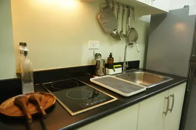 a small kitchen with a sink and a stove at Mint Homes in Jazz Residences Tower B in Manila