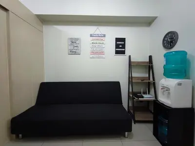 a room with a bed and a clock on the wall at Mint Homes in Jazz Residences Tower B in Manila