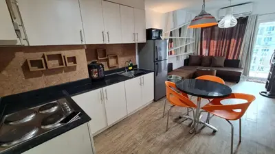 a kitchen with a table and chairs and a couch at Sea Residences - Condo R Us in Manila