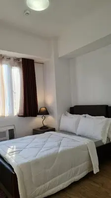 a bedroom with a large white bed in a room at Sea Residences - Condo R Us in Manila