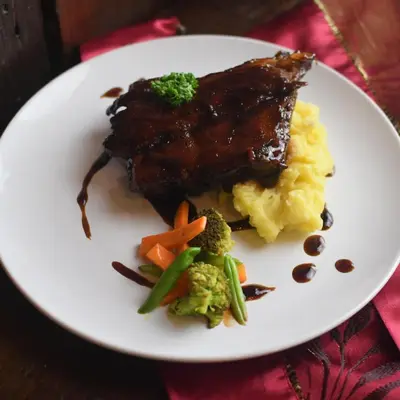 a white plate with meat and vegetables and mashed potatoes at Jade Hotel and Suites in Manila