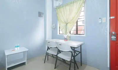 a small table and chairs in a room with a window at RedDoorz Plus near Tambo Paranaque in Manila