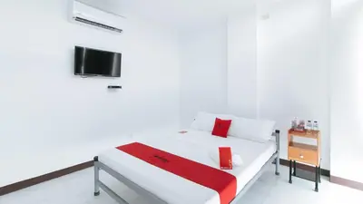 a white bedroom with a bed and a tv at RedDoorz at Good 101 Paranaque in Manila