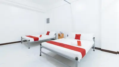 two beds in a room with white walls at RedDoorz at Good 101 Paranaque in Manila