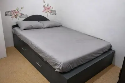 a bed with a black bed frame in a room at Transient Home at Tierra Vista near SM Dasma with Wifi and Netflix in Mabatang