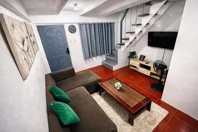 a living room with a couch and a table at Transient Home at Tierra Vista near SM Dasma with Wifi and Netflix in Mabatang