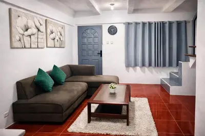 a living room with a couch and a table at Transient Home at Tierra Vista near SM Dasma with Wifi and Netflix in Mabatang