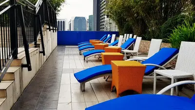 a row of chairs and tables on a balcony at Y2 Residence Hotel Managed by HII in Manila