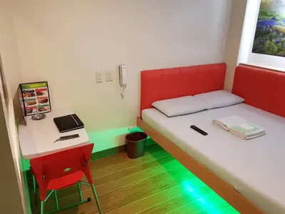 a small room with a bed and a desk at My Inn Calamba in Calamba