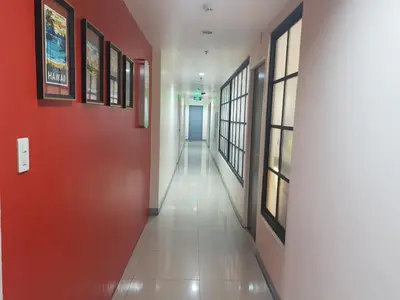 a corridor in a building with a red door at My Inn Calamba in Calamba