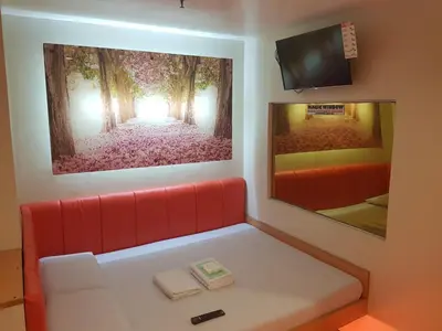 a waiting room with a red couch and a tv at My Inn Calamba in Calamba