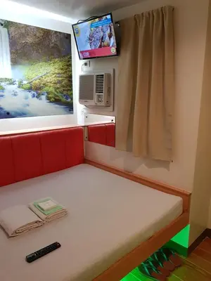 a small bed in a train room with a television at My Inn Calamba in Calamba